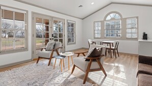 Un salon spacieux avec une grande fenêtre, un coin repas et un espace salon confortable.