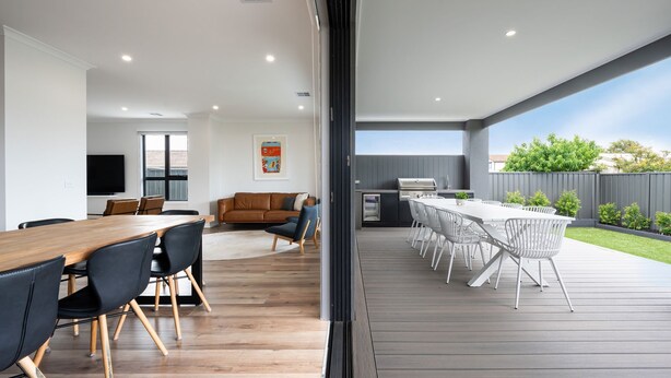 A modern kitchen with a built-in oven and a dining area with a wooden table and chairs. - Rigby Retreat at St Leonards (St Leonards)