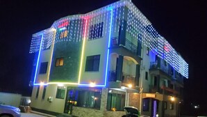 A multi-story building with a balcony on the second floor, a parking area in front, and a car parked in the lot. - Rubax motel mbarara  (Mbarara)
