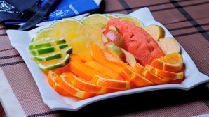 A white plate with sliced fruits including oranges, watermelon, and melon. - Rubax motel mbarara  (Mbarara)