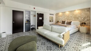 A hotel room with a bed, a sofa, a desk, and a wardrobe. - Hotel Milano (San Juan)