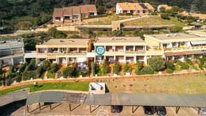 Quartiere residenziale con diverse case, un parcheggio e un edificio grande con un logo blu.