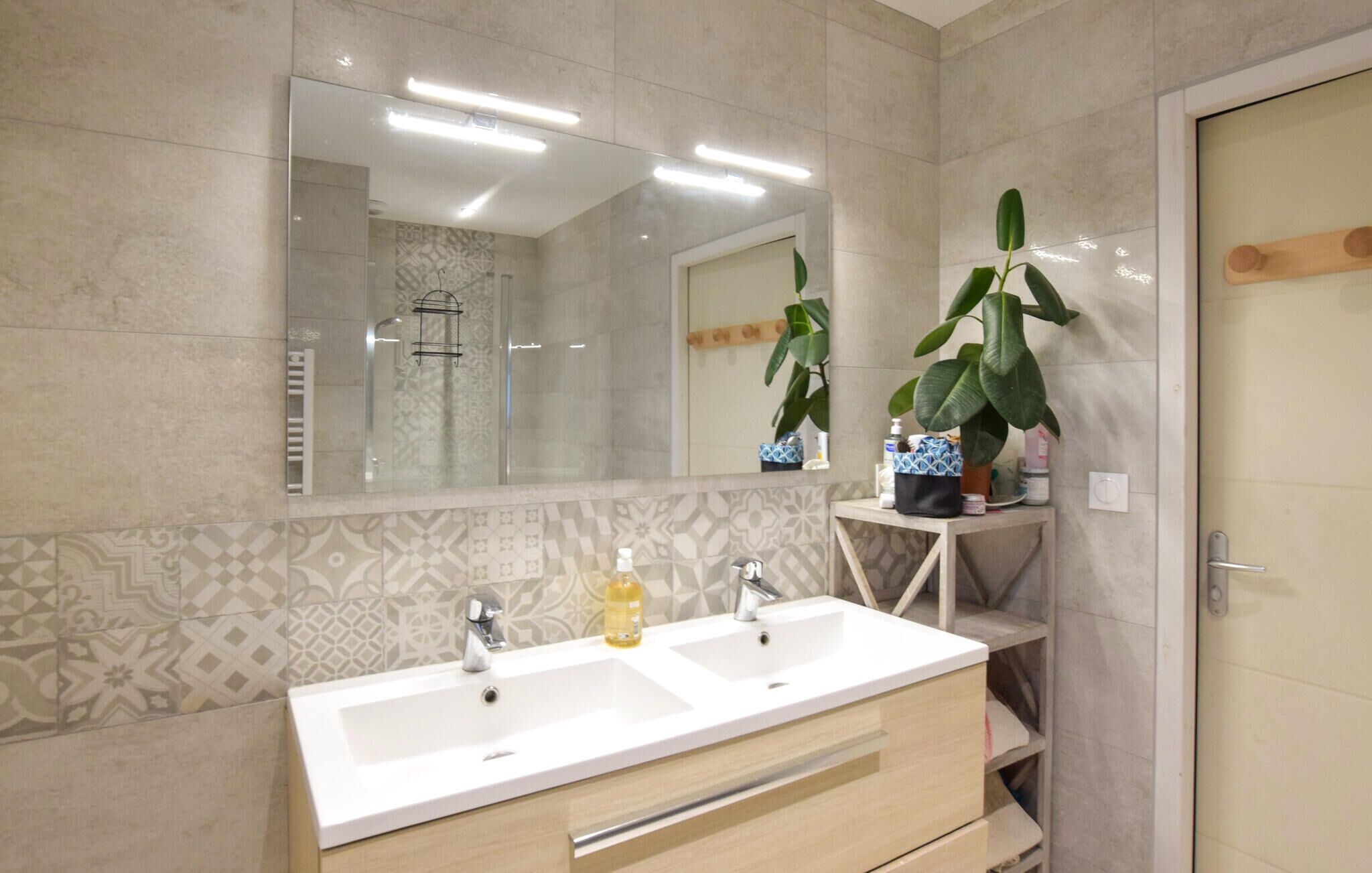 Un baño con dos lavabos, un espejo y una ducha.