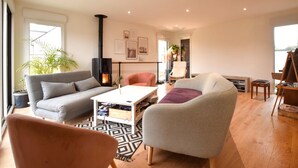 A modern living room with a sofa, armchairs, a coffee table, and a fireplace. - 3 bedroom gorgeous home in Amfreville (Amfreville)
