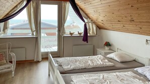 A bedroom with two beds, a window with curtains, a chair, and a nightstand with a lamp. - 3 bedroom gorgeous home in Hesselager (Hesselager)
