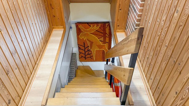 A wooden staircase with a handrail, carpeted wall, and a patterned rug at the top. - 3 bedroom gorgeous home in Hesselager (Hesselager)