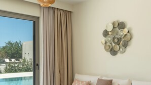 A modern living room with a white sofa, a wooden coffee table, and a view of a swimming pool. - 200m to the beach | brand new 2024 | Villa Erato - Elysian Villas (Kefalonia)