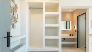A modern bathroom with a large mirror, a sink, and built-in shelves. - 200m to the beach | brand new 2024 | Villa Erato - Elysian Villas (Kefalonia)