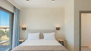 A modern hotel room with a large bed, two bedside tables, and a view of the outdoors. - 200m to the beach | brand new 2024 | Villa Erato - Elysian Villas (Kefalonia)