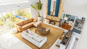 A spacious living room with a large sectional sofa, a coffee table, and a fireplace. - Exclusive Ocean Villa in Nassau (Nassau)