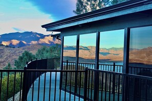 Un balcon avec vue sur les montagnes et un lac.
