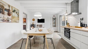 Une cuisine moderne avec des meubles blancs, un four encastré et un plan de travail en bois.