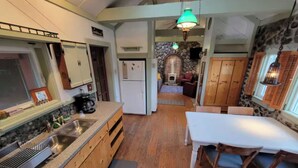 Une cuisine avec des meubles en bois, un plan de travail blanc et un coin repas comprenant une table et des chaises.