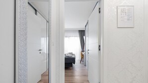 A hallway leading to a bedroom with a bed, a chair, and a window with curtains. - Stunning home in Vodice with sauna (Vodice)