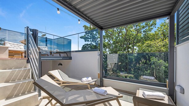 A modern outdoor lounge area with glass walls, a staircase, and a view of trees. - Stunning home in Vodice with sauna (Vodice)