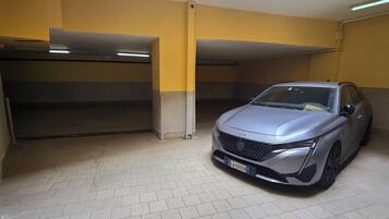 Un parking où une voiture argentée est garée dans une place.