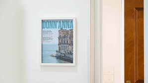 A framed poster of a historic building with the text "DONN'ANNA" on a white wall. - La Dimora Di Parthenope (Naples)