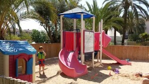A children's play area with a slide and climbing structures.