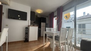 A modern apartment with a dining area, kitchen, and a balcony with a view.