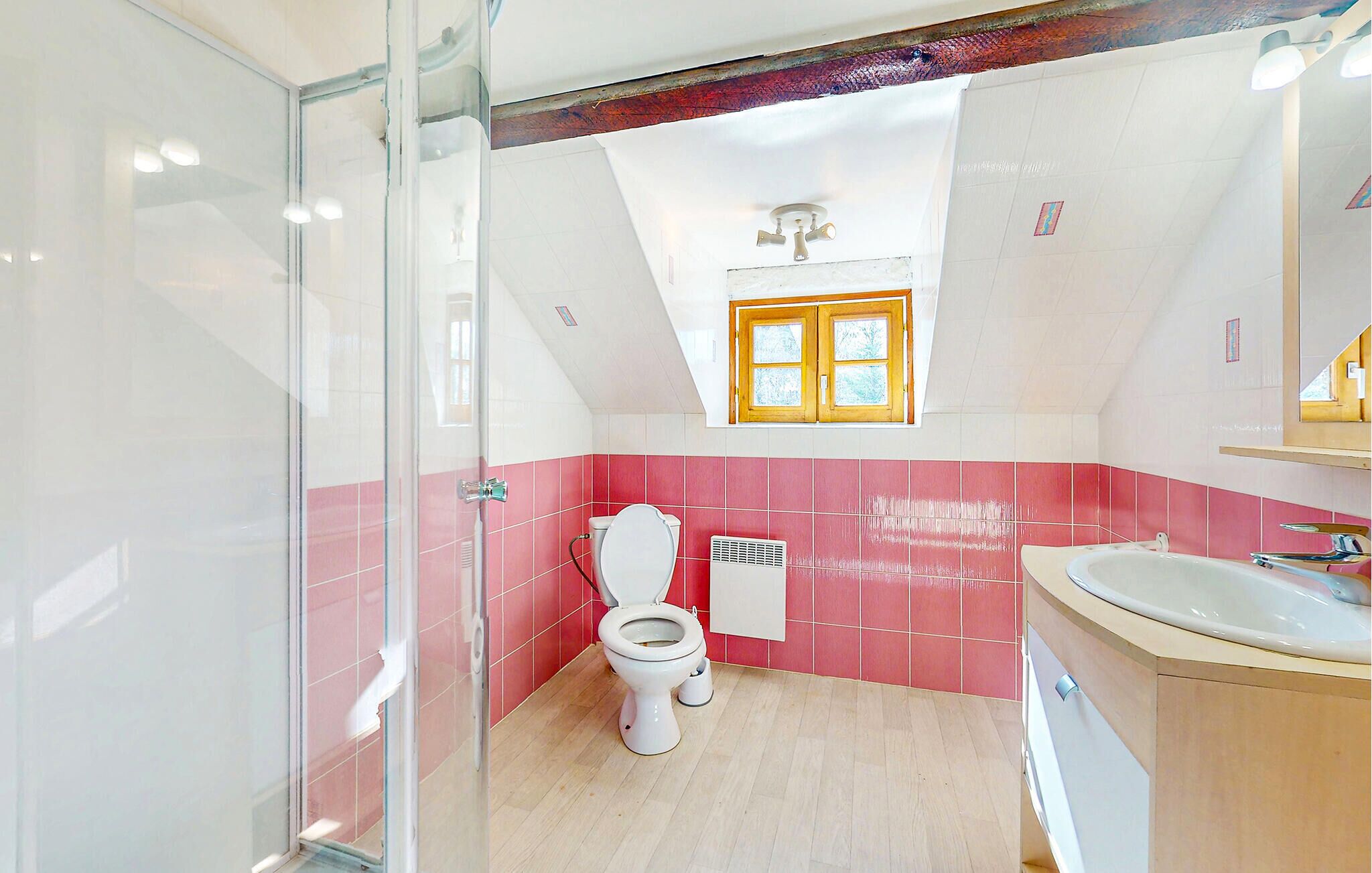 Een badkamer met douche, toilet en wastafel.