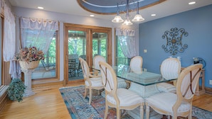 A dining area with a glass table, white upholstered chairs, and a patterned rug. - Expansive 5b6ba Countryside Home in welcoming Galena (Galena)