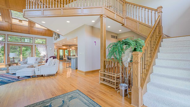A spacious living area with a wooden staircase, a dining area, and large windows. - Expansive 5b6ba Countryside Home in welcoming Galena (Galena)