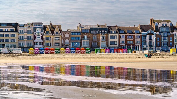 A row of colorful beach huts along a sandy beach with a reflective water surface in the foreground. - 4 bedroom gorgeous home in Petite-Synthe (Petite-Synthe)