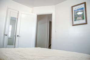 A bedroom with a bed, a door, and a framed picture on the wall. - Cozy 4-bedroom house in Sugar House, Salt Lake City with AC, WiFi (Salt Lake City)