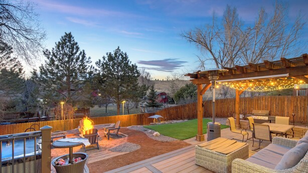 A deck with outdoor furniture, a fire pit, and string lights. - Hot Tub, Fire Pit, Bocce Ball+ (Colorado Springs)