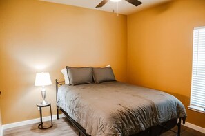 A bedroom with a bed, a nightstand, a lamp, and a ceiling fan. - New 2 BR, 2B, 231 11th. NE unit2 (Paris)