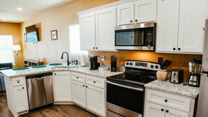 A modern kitchen with white cabinets, stainless steel appliances, and a granite countertop. - New, 2 BR, 2B,  231 11th NE, #1 (Paris)