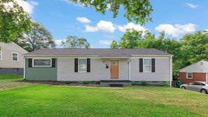 A single-story house with a front porch, a small front yard, and a garage. - Spacious 4-bedroom Modern Bungalow in Charlotte! (Charlotte)