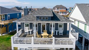 A two-story house with a balcony, a small deck, and a front porch. - Perfect Beach Getaway Home!  Beautiful property! (Bolivar Peninsula)