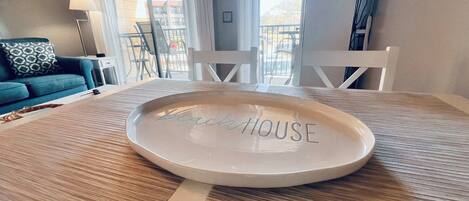 A round table with a placemat and a plate with "BeachHouse" engraved on it.