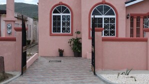 A pink building with arched windows and a tiled entrance.