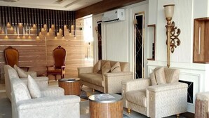A modern living room with a sofa set, two armchairs, a coffee table, and a floor lamp. - Hotel Four Square  (Karachi)