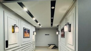 A hallway with white paneling and recessed lighting. - Hotel Four Square  (Karachi)