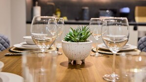 Una mesa de comedor con copas de vino y una planta en maceta.