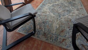 A room with a large sliding glass door leading to a pool, a black metal chair, a patterned rug, a wooden cabinet, and an air conditioning unit. - Escape & relaxation in the real Spain!
Amazing mountain vistas, pool with views (Cuesta Blanca)