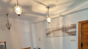 A living room with a sofa, a coffee table with a vase, patterned carpet, and hanging light fixtures. - Escape & relaxation in the real Spain!
Amazing mountain vistas, pool with views (Cuesta Blanca)