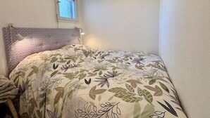 A small, cozy bedroom with a single bed, a window, and a wall-mounted shelf. - Quiberon - 2rooms - 27m² - beach (QUIBERON)
