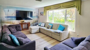A living room with a grey sofa set, a white sofa, and a TV on the wall. - Free Huge Heated Pool, Spacious, Comfy Beachy Vibes! (Largo)