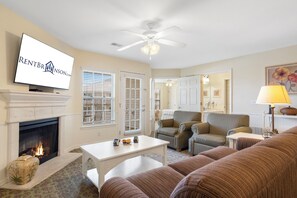 A living room with a fireplace, television, and seating area. - Expansive Condo with Community Pool, Scenic Lake Access, Serene Views, & Free Tickets! (Kimberling City)