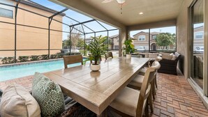A covered patio with a pool, outdoor seating, and a ceiling fan. - Stylish Orlando Resort Home w Private Pool (Kissimmee)