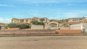 Un quartier résidentiel avec des maisons, une entrée sécurisée et un ciel dégagé.