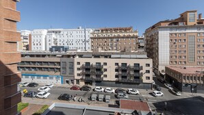 A multi-story building with a parking lot in front, featuring a mix of residential and commercial spaces. - Apartment 'Chick' with Wi-Fi and Air Conditioning (Sevilla)