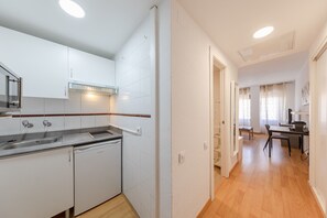 Eine moderne Küche mit weißen Schränken, einem Geschirrspüler und einem eingebauten Backofen.