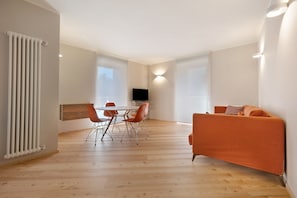 Un salon moderne comprenant un coin repas, un canapé et un téléviseur.