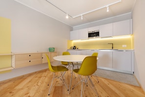 A modern kitchen with white cabinets, a stainless steel oven, and a yellow-lit countertop. - Apartment 'Yellow' with Mountain View, Balcony and Wi-Fi (Carisolo)