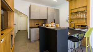 Une cuisine moderne dotée d’un îlot central, de meubles en bois et d’un coin repas avec des chaises.